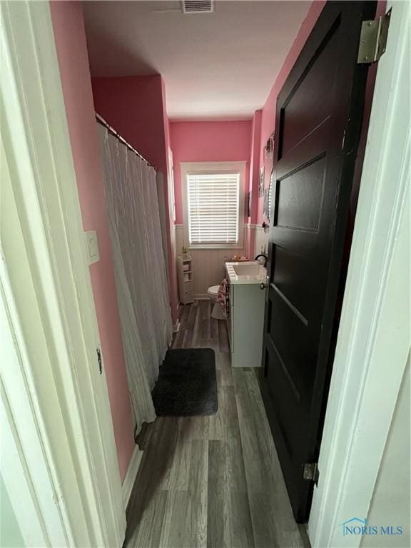 laundry area featuring visible vents, a sink, and light wood finished floors