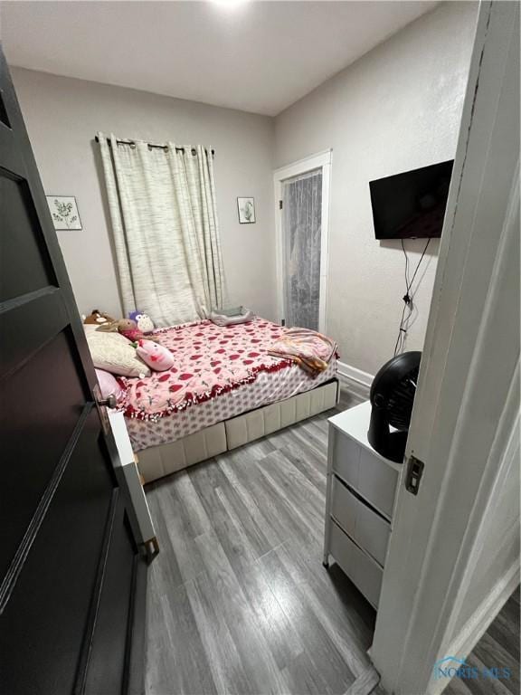 bedroom with baseboards and wood finished floors
