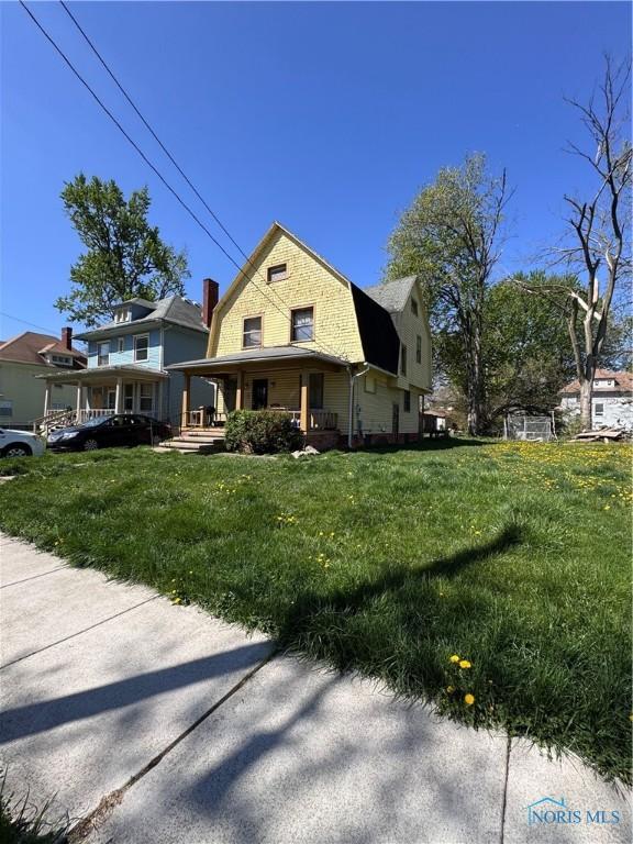 2435 Warren St, Toledo, OH 43620 - view of front facade with a gambrel roof, a front lawn, and covered porch
