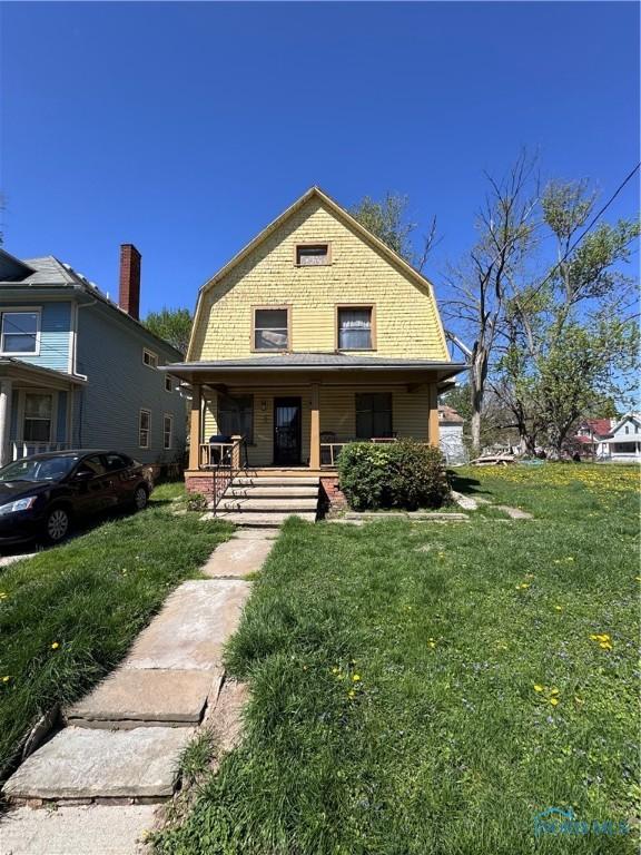 2435 Warren St, Toledo, OH 43620 - colonial inspired home with covered porch, a front yard, and a gambrel roof