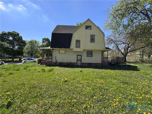 2435 Warren St, Toledo, OH 43620 - view of side of property with a lawn, a deck, a shingled roof, and a gambrel roof