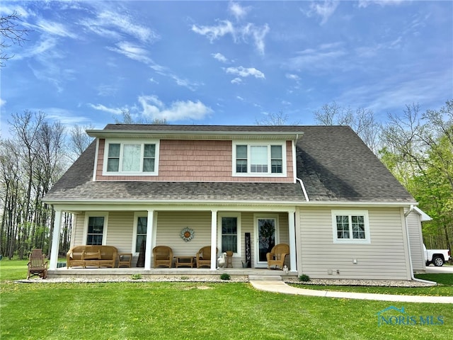 view of front of home with a porch, a shingled roof, and a front yard