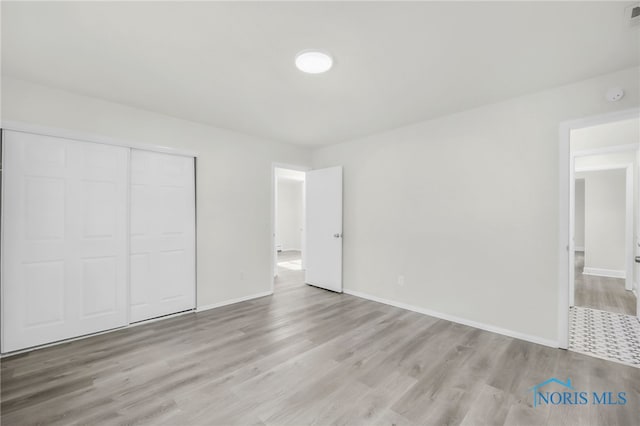 6040 Rolland Dr, Toledo, OH 43612 - unfurnished bedroom with wood finished floors, a closet, and baseboards