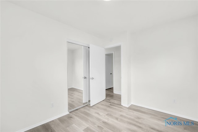 6040 Rolland Dr, Toledo, OH 43612 - unfurnished bedroom featuring light wood-type flooring, a closet, and baseboards