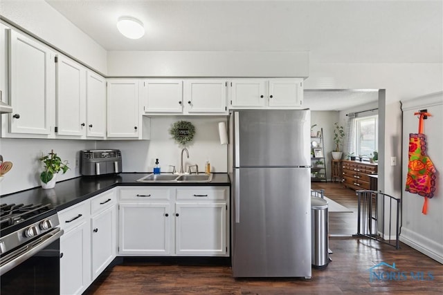 2123 Keen Ave, Toledo, OH 43611 - kitchen with white cabinets, appliances with stainless steel finishes, a sink, and dark wood-type flooring