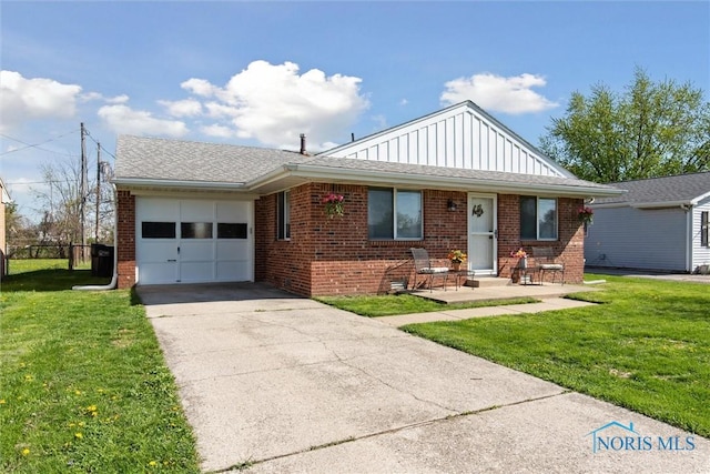2123 Keen Ave, Toledo, OH 43611 - ranch-style home with board and batten siding, driveway, brick siding, a front lawn, and an attached garage