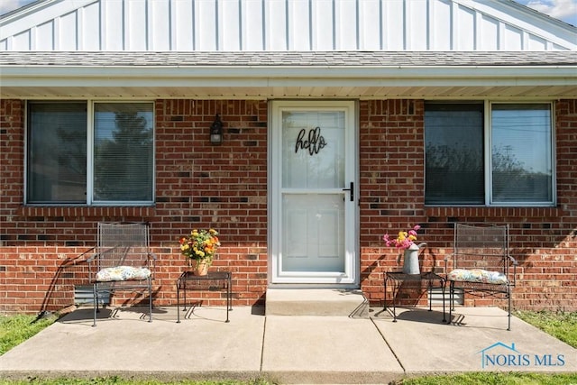2123 Keen Ave, Toledo, OH 43611 - property entrance with board and batten siding, brick siding, and a patio