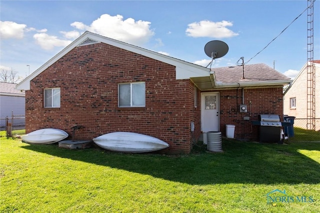 2123 Keen Ave, Toledo, OH 43611 - rear view of house with fence, a lawn, and brick siding