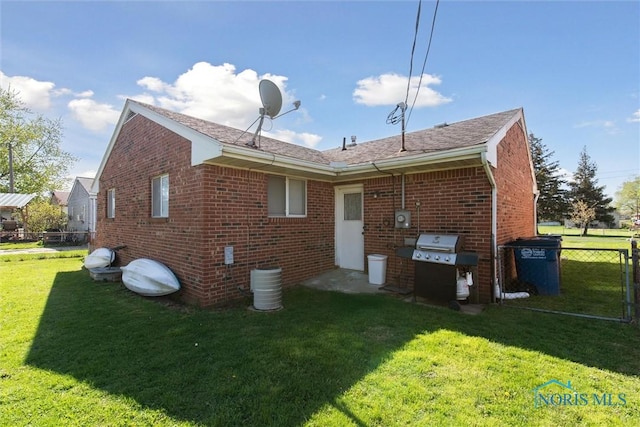 2123 Keen Ave, Toledo, OH 43611 - back of house featuring a lawn, fence, roof with shingles, and brick siding