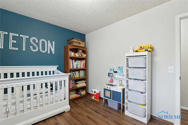 2123 Keen Ave, Toledo, OH 43611 - bedroom with a nursery area, a textured ceiling, and wood finished floors