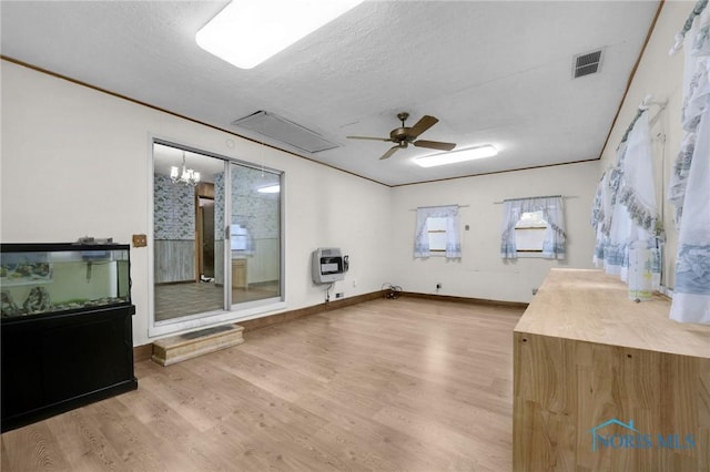 13921 Defiance Pike, Rudolph, OH 43462 - spare room featuring heating unit, light wood finished floors, a ceiling fan, baseboards, and a textured ceiling
