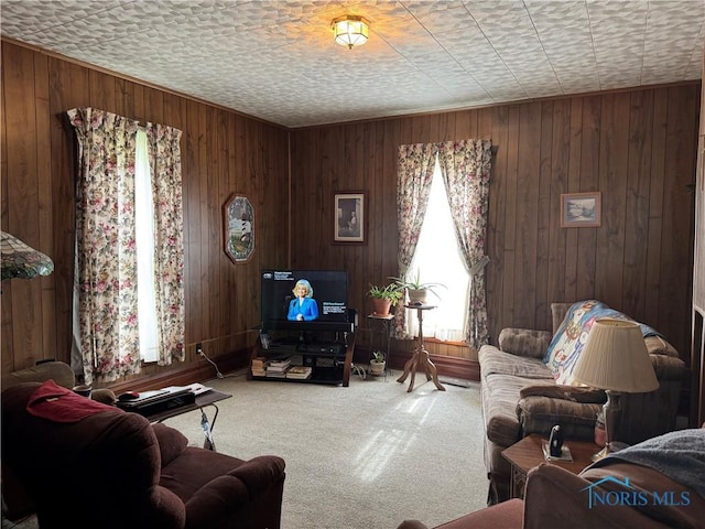 carpeted living room featuring wood walls