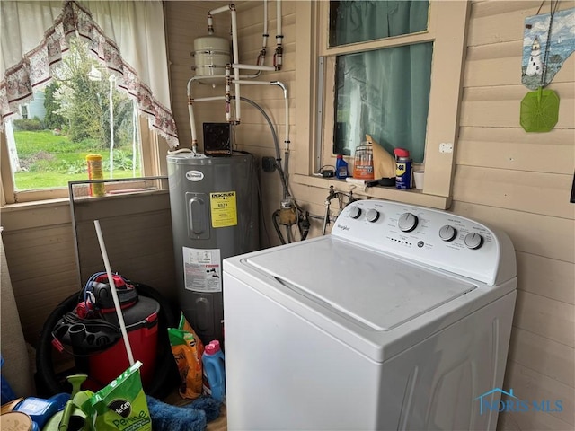 laundry area with washer / clothes dryer, laundry area, wood walls, and water heater