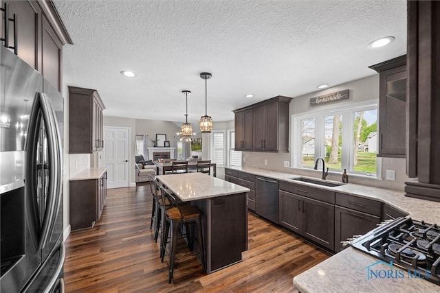 1135 Pimlico Park, Holland, OH 43528 - kitchen featuring dark brown cabinets, dark wood-type flooring, a center island, a sink, and stainless steel appliances