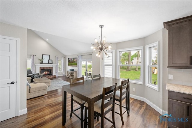 1135 Pimlico Park, Holland, OH 43528 - dining space featuring a fireplace, baseboards, dark wood-type flooring, a notable chandelier, and vaulted ceiling