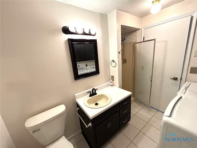 full bathroom with vanity, toilet, tile patterned floors, a textured ceiling, and washer / clothes dryer