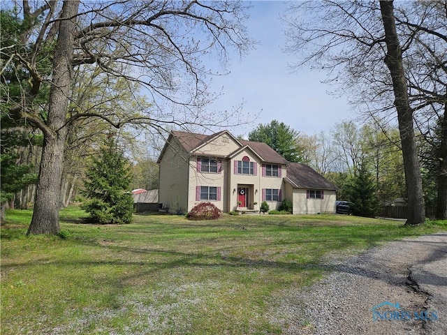 view of front of house featuring a shingled roof, gravel driveway, and a front yard