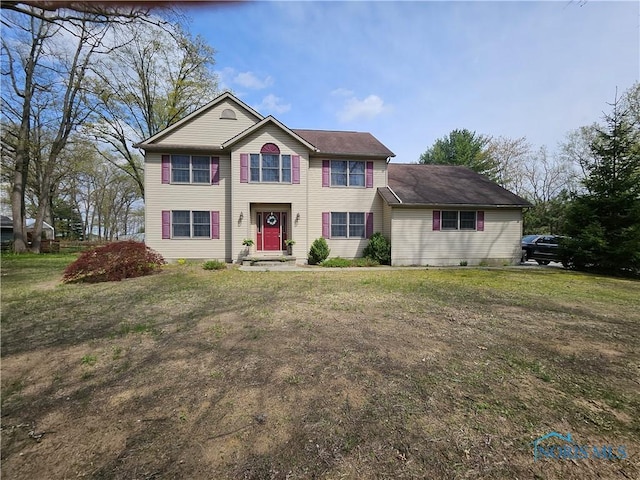 colonial inspired home featuring a front lawn