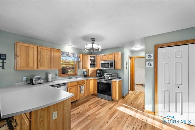 2515 S Berkey Southern Rd, Swanton, OH 43558 - kitchen with appliances with stainless steel finishes, light wood-type flooring, a peninsula, light countertops, and a sink