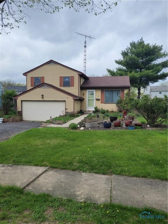 split level home featuring a garage, driveway, and a front yard