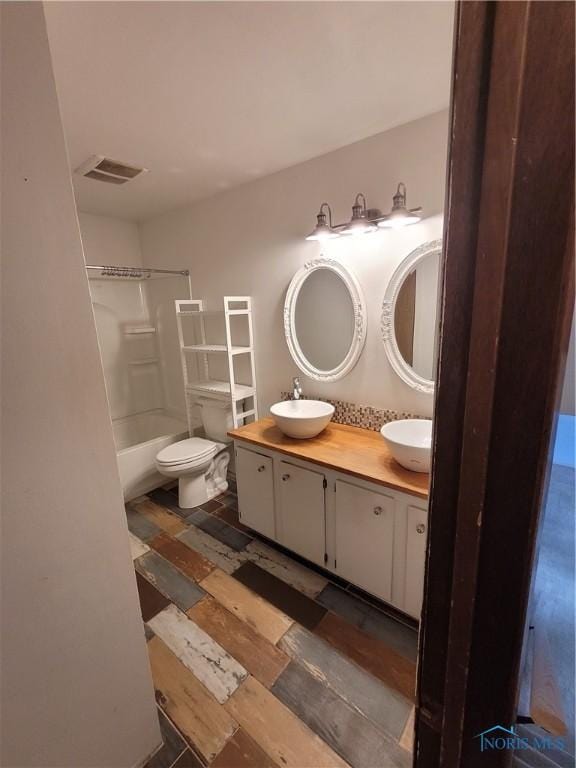 633 Southfield Dr, Maumee, OH 43537 - full bathroom featuring double vanity, wood finished floors, shower / tub combination, and toilet