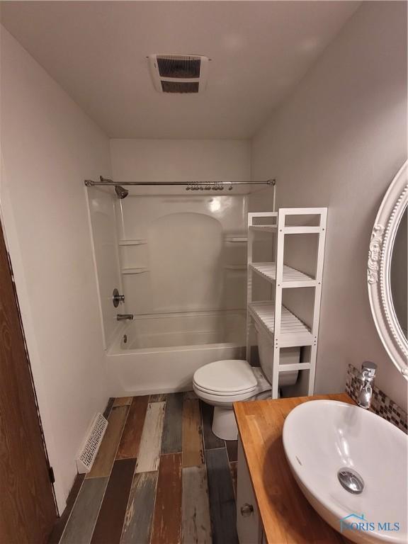 633 Southfield Dr, Maumee, OH 43537 - bathroom featuring  shower combination, vanity, wood finished floors, and toilet