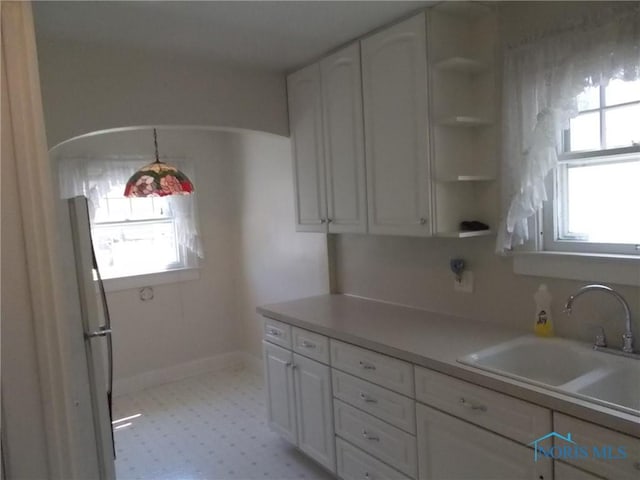 kitchen with plenty of natural light, white cabinets, and open shelves