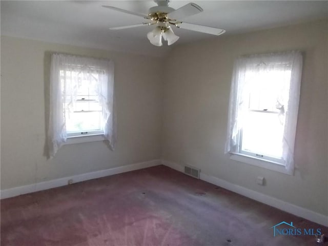 empty room featuring a ceiling fan, baseboards, visible vents, and a healthy amount of sunlight