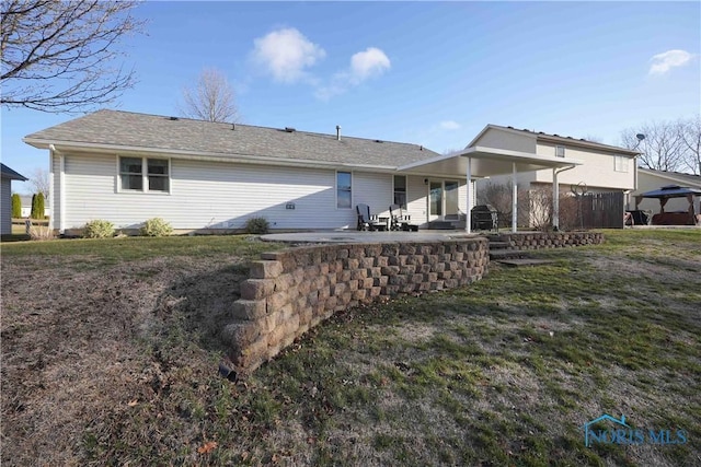 back of property featuring a patio, a yard, and a gazebo