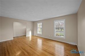 unfurnished living room featuring baseboards and wood finished floors