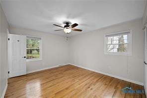 unfurnished room with baseboards, ceiling fan, and wood finished floors