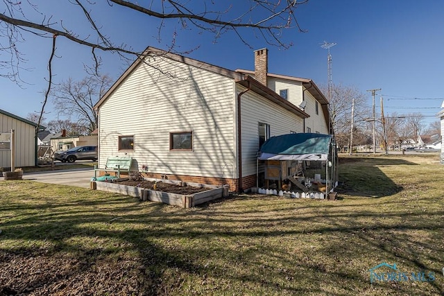 back of property featuring a lawn and a chimney