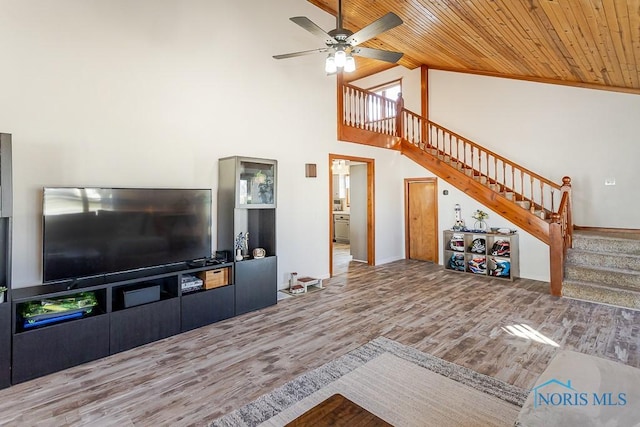 unfurnished living room with wood ceiling, ceiling fan, wood finished floors, stairway, and high vaulted ceiling