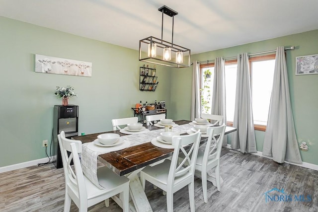 dining space featuring baseboards and light wood-type flooring