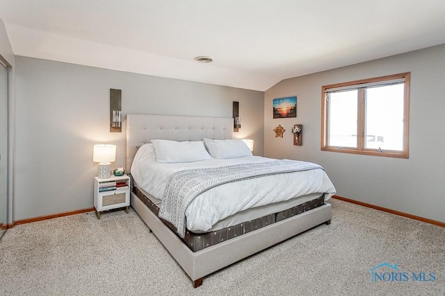 carpeted bedroom featuring baseboards, vaulted ceiling, and visible vents