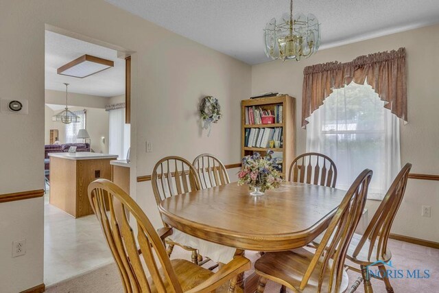 3739 Wild Pheasant Ln, Sylvania, OH 43560 - dining area featuring baseboards, a chandelier, and a textured ceiling