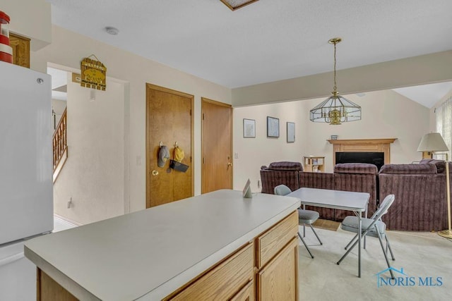 3739 Wild Pheasant Ln, Sylvania, OH 43560 - kitchen with freestanding refrigerator, open floor plan, a fireplace, a center island, and light countertops