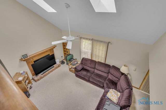 3739 Wild Pheasant Ln, Sylvania, OH 43560 - living area featuring a skylight, a glass covered fireplace, vaulted ceiling, carpet floors, and a ceiling fan