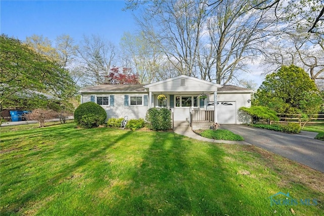 ranch-style home with a porch, driveway, a front lawn, and a garage