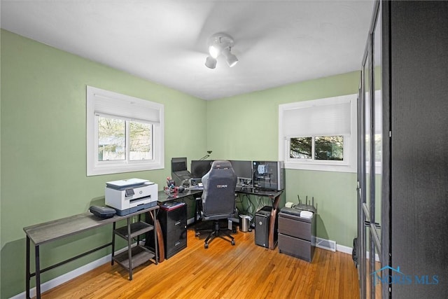 home office with baseboards, wood finished floors, and a wealth of natural light