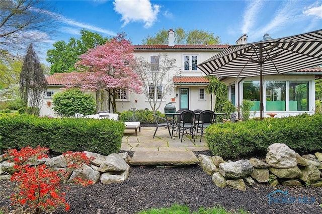 3405 Chestnut Hill Rd, Ottawa Hills, OH 43606 - back of property with stucco siding, a patio area, a chimney, and a tiled roof