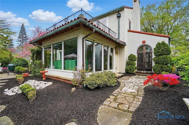 3405 Chestnut Hill Rd, Ottawa Hills, OH 43606 - rear view of property featuring a sunroom, stucco siding, french doors, and a chimney