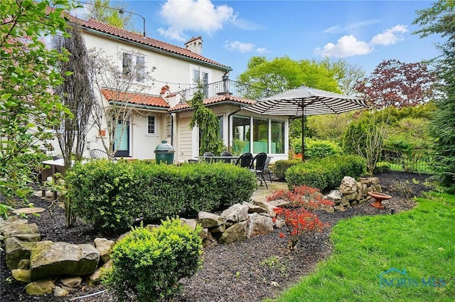 3405 Chestnut Hill Rd, Ottawa Hills, OH 43606 - back of property featuring a balcony, a chimney, a tiled roof, stucco siding, and a patio