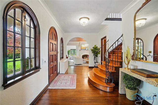 3405 Chestnut Hill Rd, Ottawa Hills, OH 43606 - foyer entrance featuring arched walkways, wood finished floors, ornamental molding, stairway, and a chandelier
