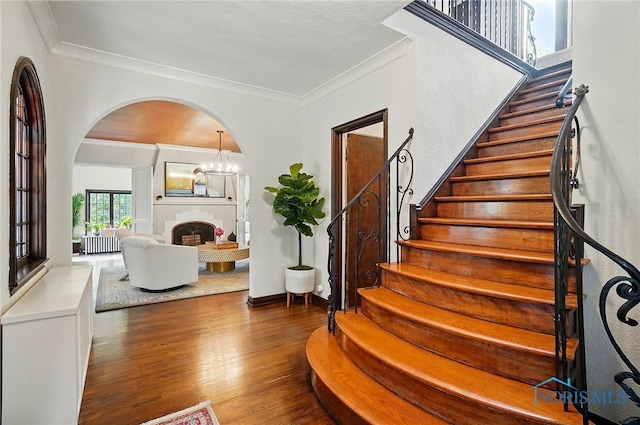 3405 Chestnut Hill Rd, Ottawa Hills, OH 43606 - stairs featuring wood finished floors, arched walkways, crown molding, a fireplace, and radiator