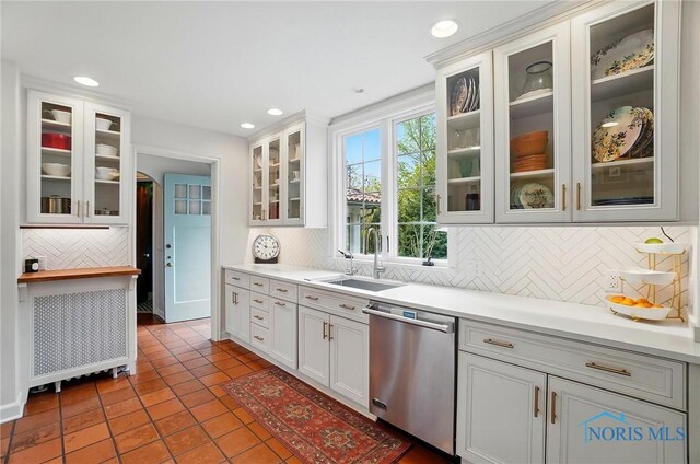 3405 Chestnut Hill Rd, Ottawa Hills, OH 43606 - kitchen with stainless steel dishwasher, a sink, tile patterned flooring, tasteful backsplash, and light countertops