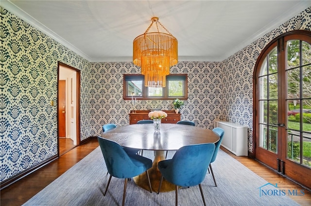 3405 Chestnut Hill Rd, Ottawa Hills, OH 43606 - dining room featuring ornamental molding, wood finished floors, a chandelier, wallpapered walls, and french doors