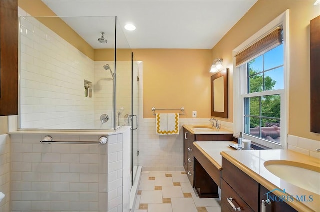 3405 Chestnut Hill Rd, Ottawa Hills, OH 43606 - full bathroom featuring a stall shower, tile walls, two vanities, a wainscoted wall, and tile patterned flooring