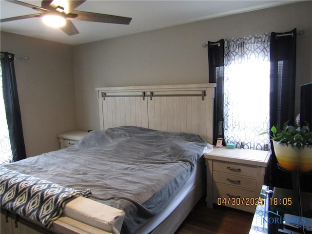 bedroom featuring a ceiling fan and dark wood-style flooring