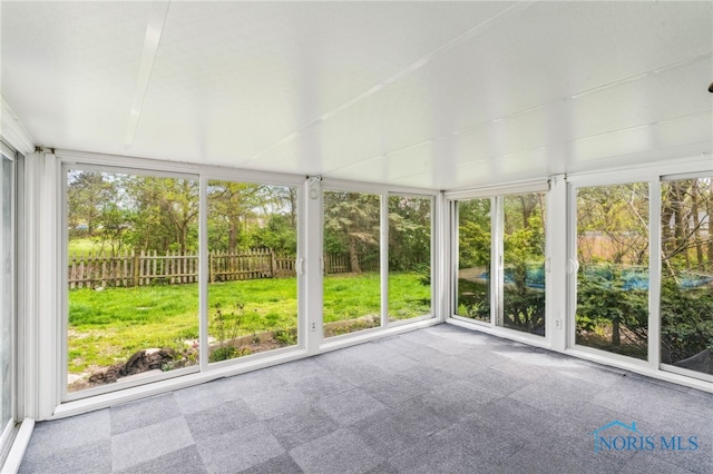 unfurnished sunroom with carpet floors